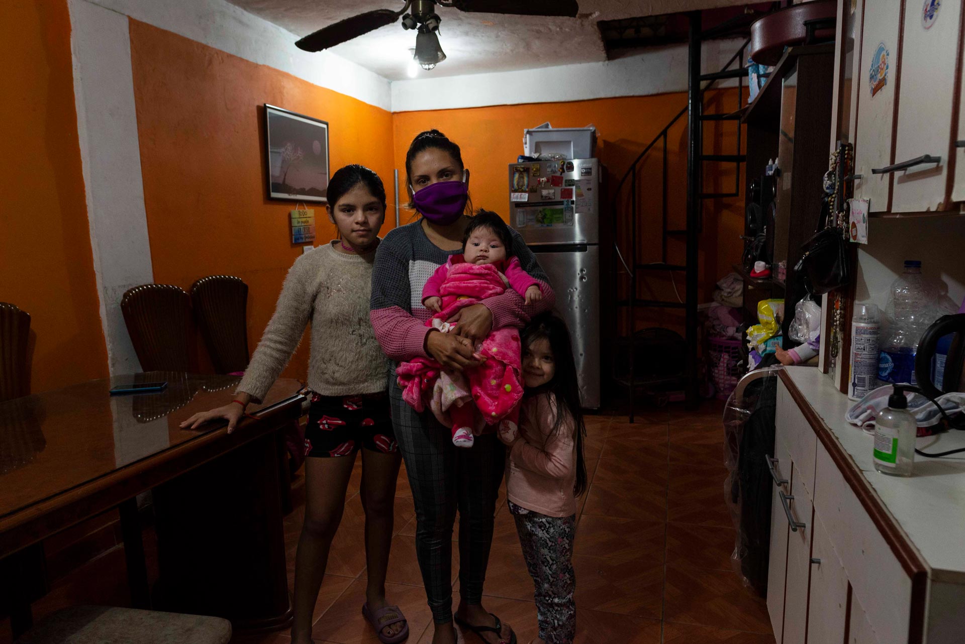 El camión no llega a la casa de Ana que vive con sus tres hijas y su marido. Ambos son vendedores ambulantes. Por la pandemia ella está sin trabajo. Hace 10 días que la familia no tiene agua. Ana (26) posa para esta fotografía con sus hijas Agostina (10), Juana (5) y Lara (3 meses). 